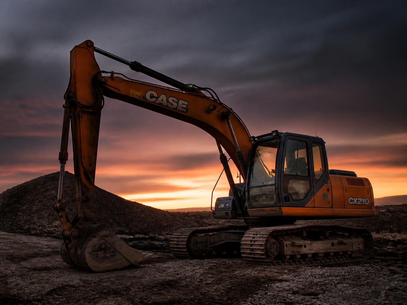 Excavator parked on a job site at dusk